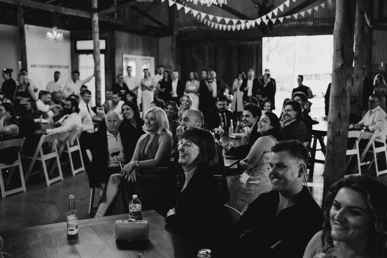 Black and white photo of wedding guests reacting during a Melbourne reception